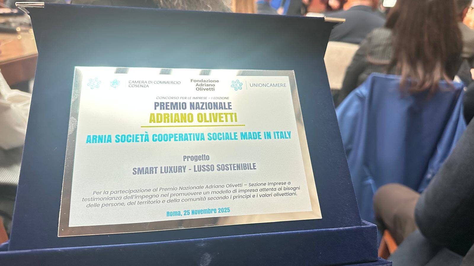 Award plaque showing 'Premio Nazionale Adriano Olivetti' with 'Arnia Società Cooperativa Sociale Made in Italy' and project 'Smart Luxury - Lusso Sostenibile'. Roma, 25 Novembre 2025.